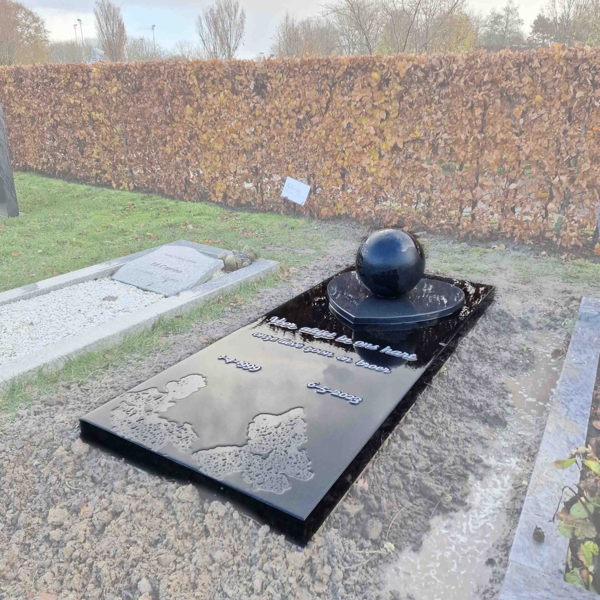 Grafsteen met wereldbol